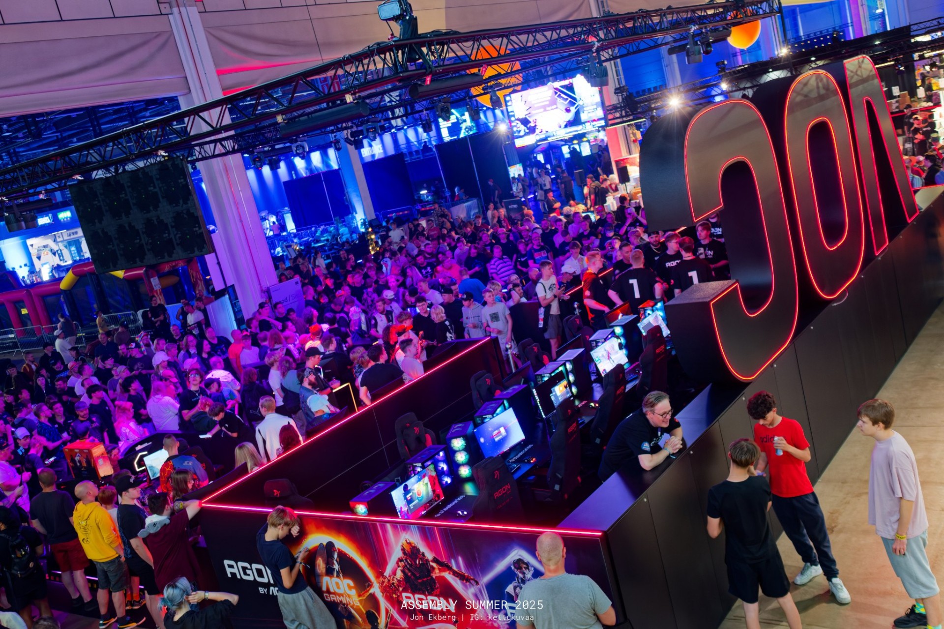 Crowd of attendees gathered around a competitive gaming setup at Assembly